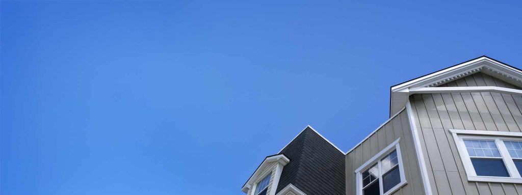 Graues Einfamilienhaus mit Giebel und blauem Himmel in Dresden