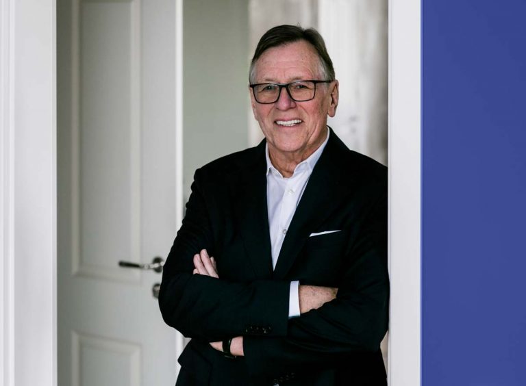 Detlef Trenner mit verschränkten Armen vor heller Tür, Immobilienberater in Dresden