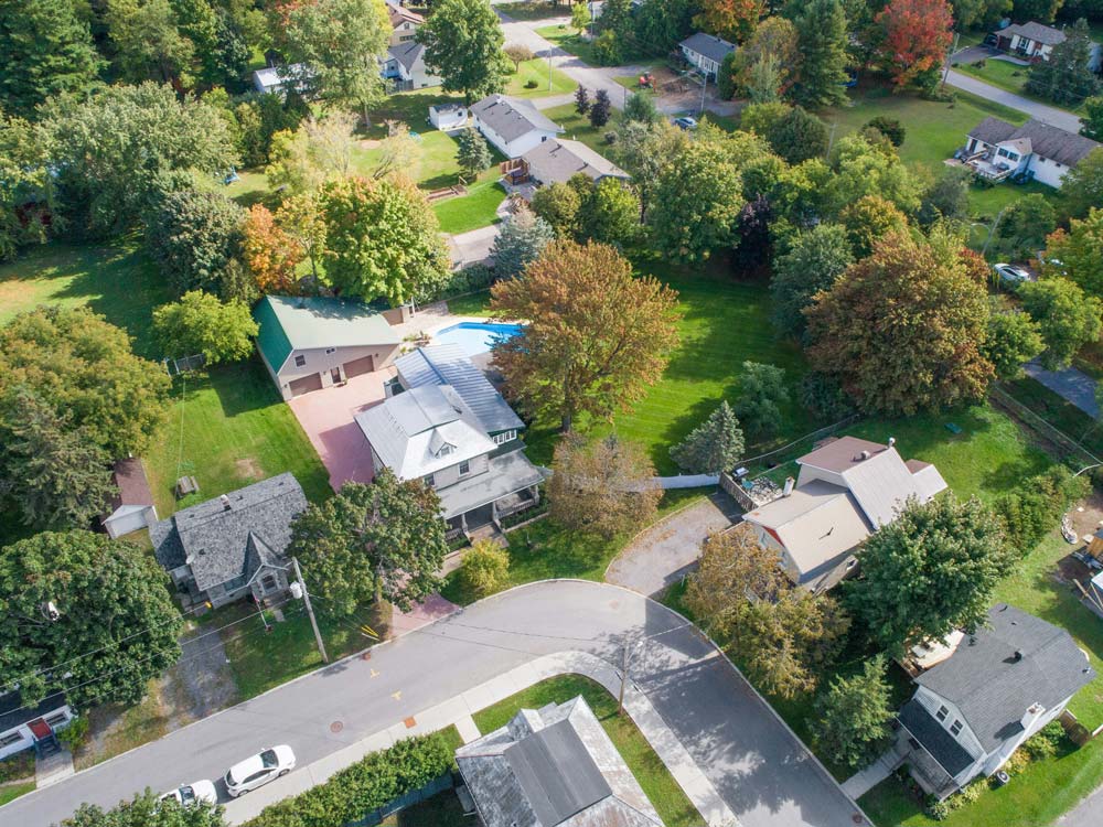 Luftaufnahme einer grünen Wohnsiedlung mit Einfamilienhäusern und Gärten, idyllisches Wohnen am Stadtrand