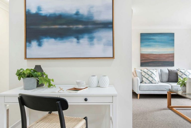 Helles Wohnzimmer mit Schreibtisch, moderner Kunst und gemütlichem Sofa – stilvolle Einrichtung